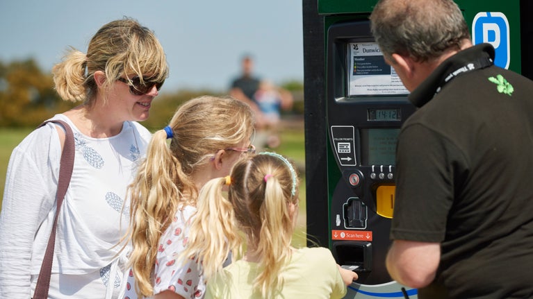 Volunteer helping visitors with the car park ticket machine.